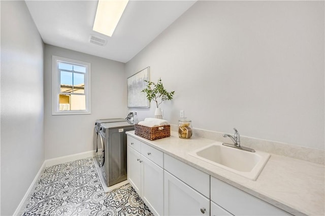 laundry room with cabinet space, light tile patterned floors, visible vents, independent washer and dryer, and a sink