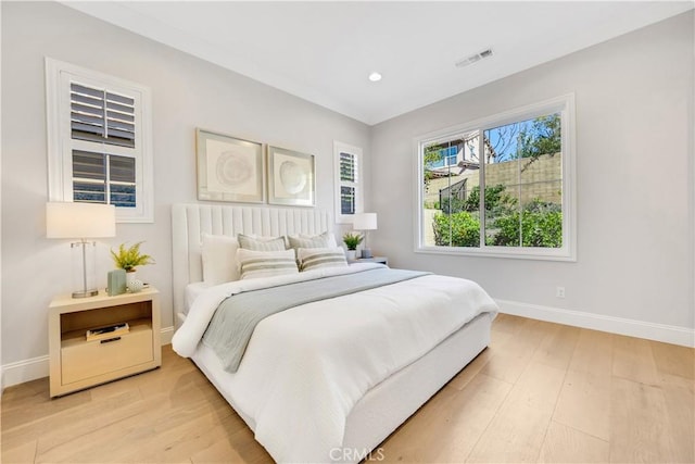 bedroom with light wood finished floors, recessed lighting, visible vents, and baseboards