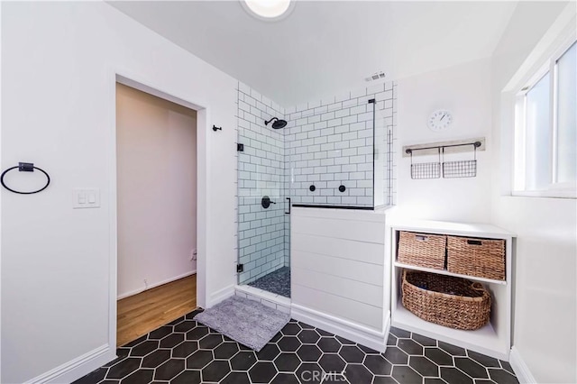 full bath featuring a shower stall, visible vents, and baseboards