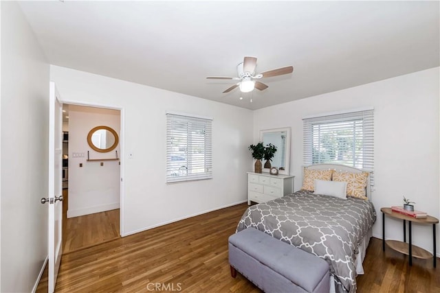 bedroom with ceiling fan, dark wood-style flooring, and baseboards