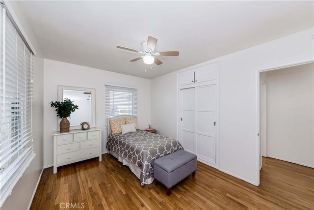 bedroom with a ceiling fan, a closet, and wood finished floors