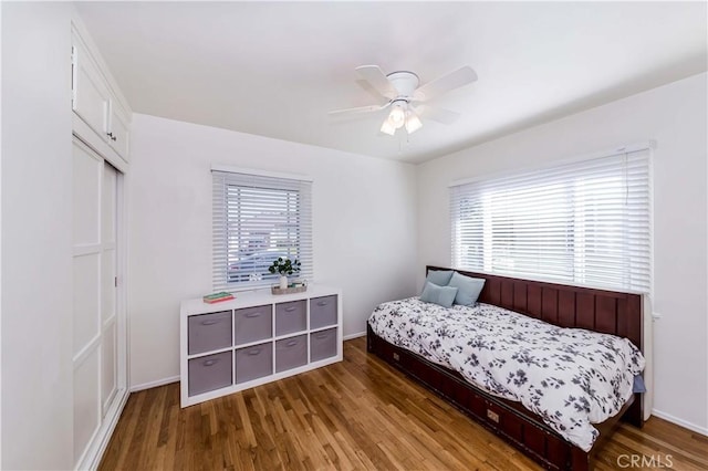 bedroom with ceiling fan, baseboards, and wood finished floors