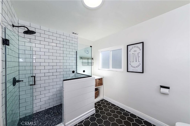 bathroom featuring a stall shower and baseboards