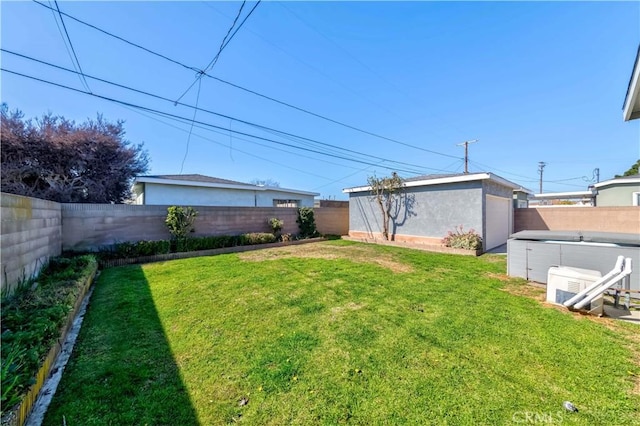 view of yard with a fenced backyard and a detached garage