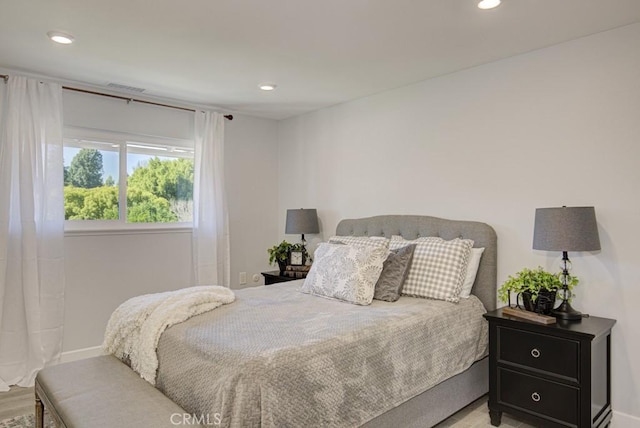 bedroom featuring visible vents, baseboards, wood finished floors, and recessed lighting