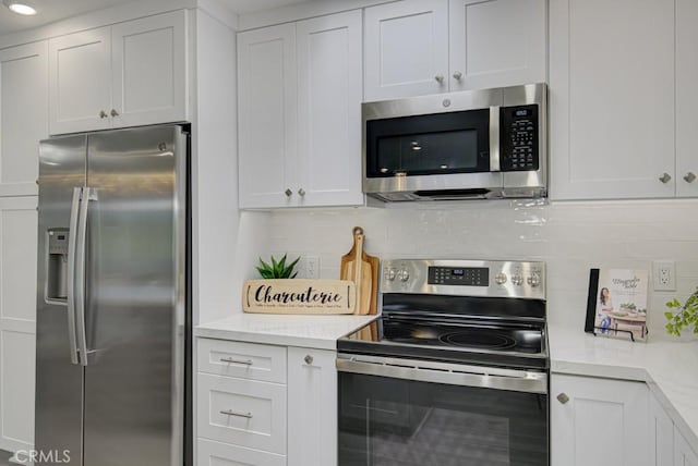 kitchen featuring tasteful backsplash, appliances with stainless steel finishes, and white cabinets