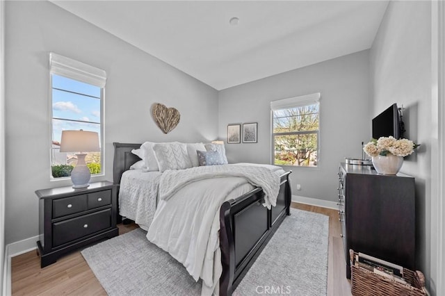 bedroom with baseboards and light wood-style floors