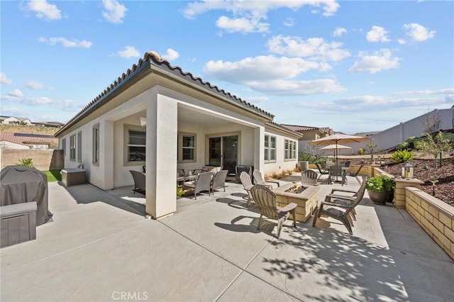 view of patio featuring a grill, fence, and a fire pit