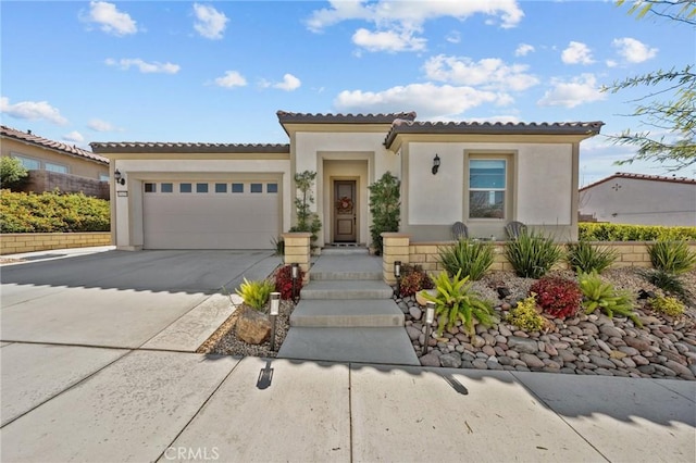 mediterranean / spanish-style house with concrete driveway, a tiled roof, a garage, and stucco siding