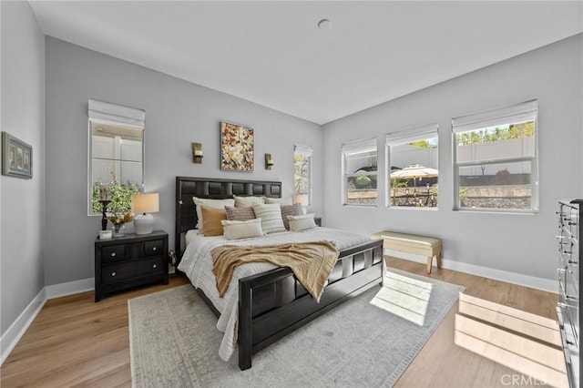 bedroom featuring light wood-style floors and baseboards