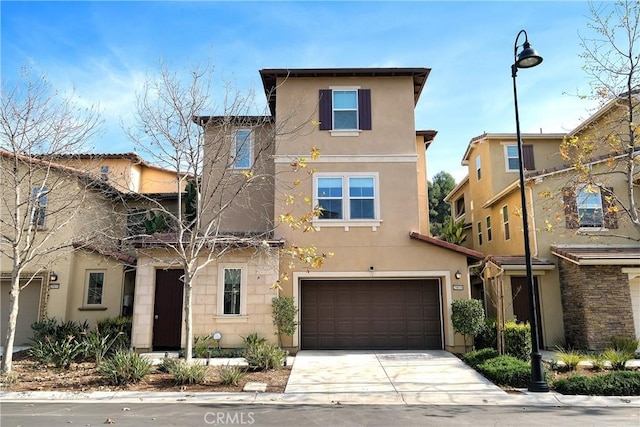 view of front of home featuring a garage, concrete driveway, and stucco siding