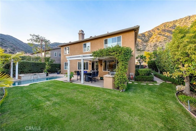 rear view of house featuring an in ground hot tub, a yard, a pergola, stucco siding, and a patio area