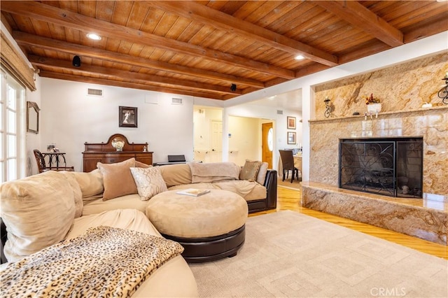 living room featuring wood ceiling, a high end fireplace, wood finished floors, and beamed ceiling