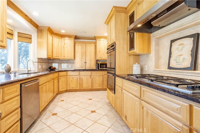 kitchen with wall chimney exhaust hood, light brown cabinets, appliances with stainless steel finishes, and a sink