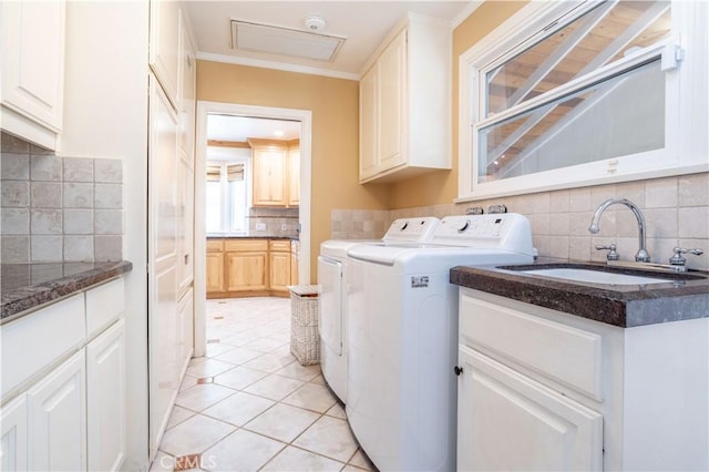 laundry room featuring light tile patterned floors, a sink, ornamental molding, cabinet space, and washing machine and clothes dryer