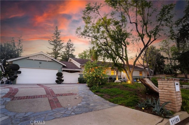 ranch-style house featuring decorative driveway and an attached garage