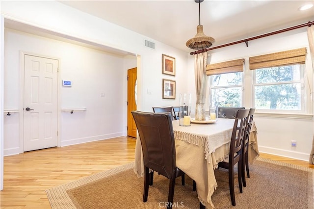 dining room with wood finished floors, visible vents, and baseboards