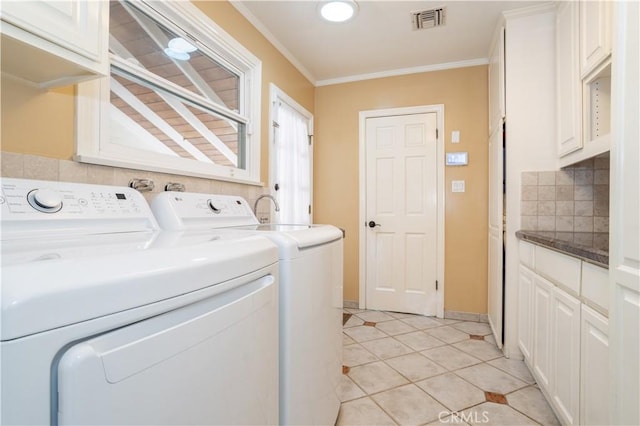 washroom with light tile patterned flooring, visible vents, washer and dryer, cabinet space, and crown molding