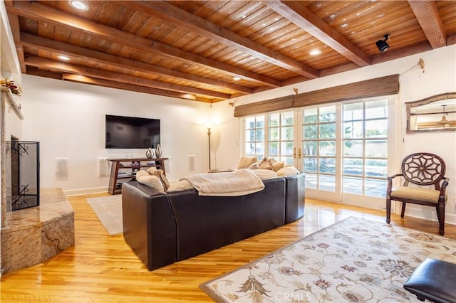 living room with wooden ceiling, a fireplace, beamed ceiling, and french doors