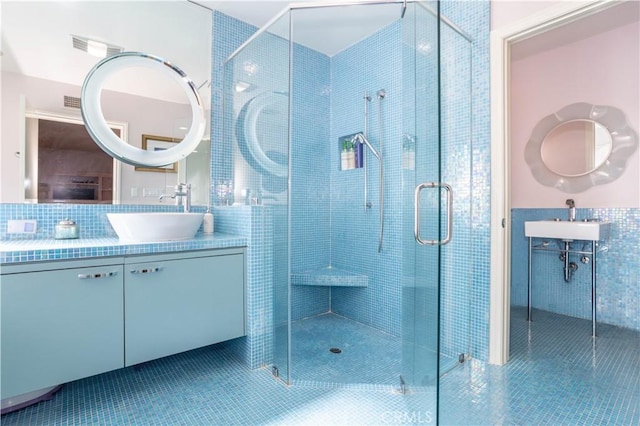 bathroom featuring visible vents, tile patterned floors, vanity, a shower stall, and tile walls