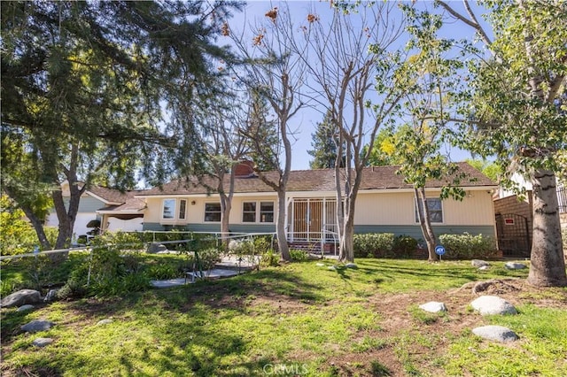 view of front of home featuring fence and a front lawn