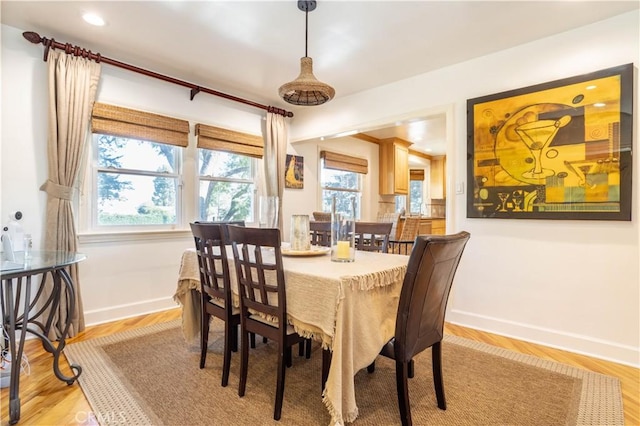 dining area with plenty of natural light, light wood-style flooring, and baseboards