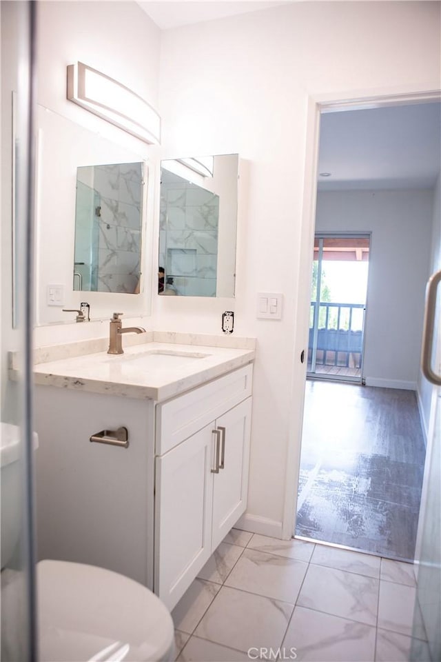 full bath featuring marble finish floor, baseboards, vanity, and a shower stall