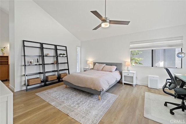 bedroom with light wood-style floors, ceiling fan, high vaulted ceiling, and baseboards