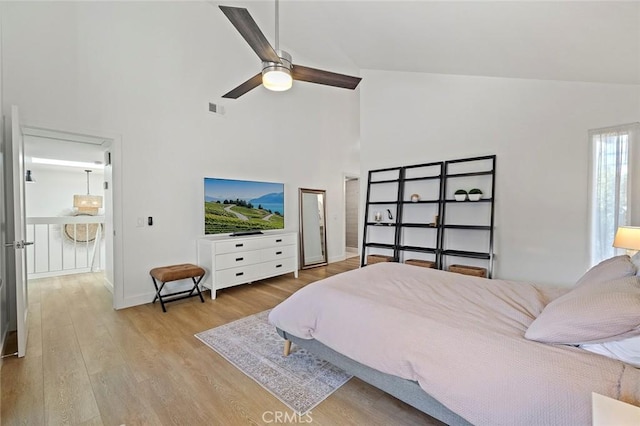 bedroom with visible vents, a ceiling fan, wood finished floors, high vaulted ceiling, and baseboards