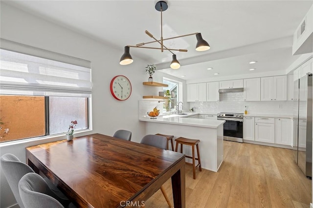 dining area featuring light wood-style floors and visible vents