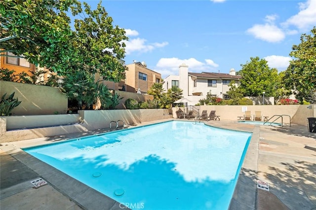 community pool featuring a patio area and fence