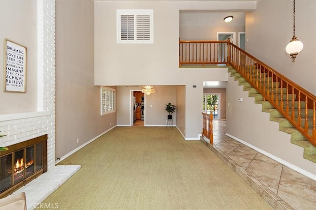 unfurnished living room featuring visible vents, a fireplace, stairway, and carpet flooring