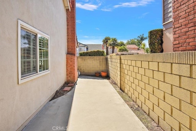 view of side of property featuring a fenced backyard and stucco siding