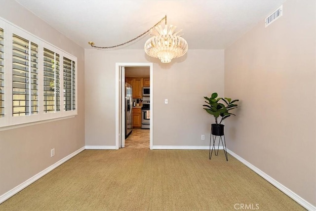 unfurnished room with light carpet, baseboards, visible vents, and a notable chandelier