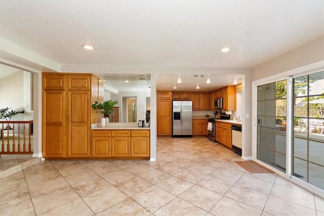 kitchen featuring recessed lighting, stainless steel appliances, baseboards, light countertops, and brown cabinets