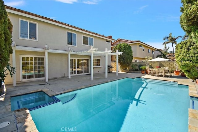 view of pool featuring a pool with connected hot tub, fence, a patio, and a pergola