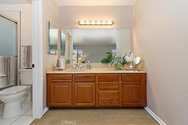 full bathroom featuring toilet, a shower with shower door, baseboards, and vanity