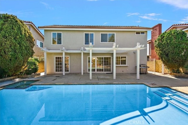 rear view of property featuring fence, an outdoor pool, a pergola, and stucco siding