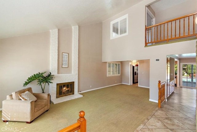 living area featuring light carpet, a high ceiling, a fireplace, and baseboards