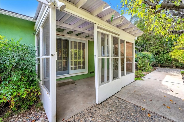 view of home's exterior with a sunroom and a patio