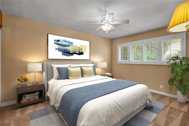 carpeted bedroom featuring a ceiling fan, baseboards, and a textured ceiling