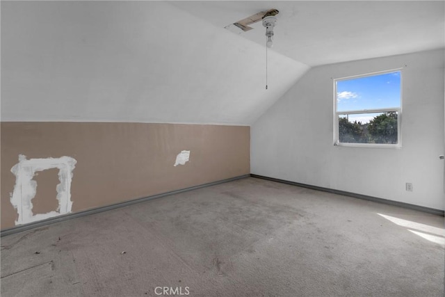 bonus room featuring vaulted ceiling and carpet