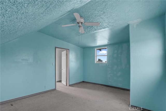 interior space featuring carpet floors, a textured ceiling, baseboards, and a ceiling fan