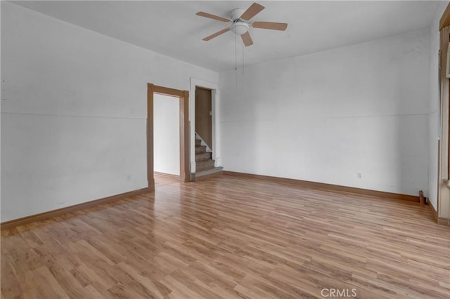 unfurnished room featuring light wood-type flooring, ceiling fan, and baseboards