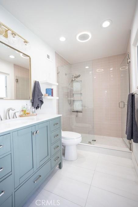 full bath featuring tile patterned flooring, toilet, visible vents, vanity, and a shower stall