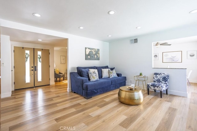 living room with light wood-style floors, recessed lighting, visible vents, and french doors