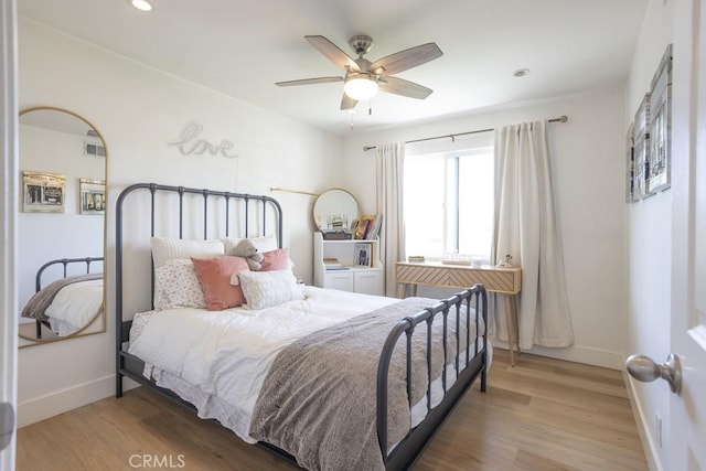 bedroom featuring baseboards, wood finished floors, and recessed lighting