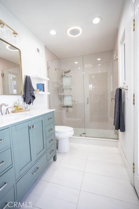 full bath featuring recessed lighting, a shower stall, vanity, and toilet