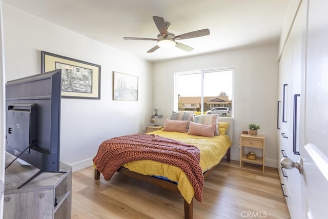 bedroom featuring light wood-style floors, ceiling fan, and baseboards