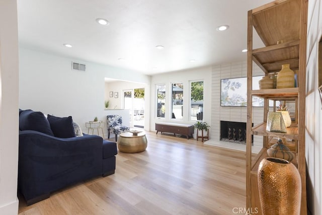 living area with light wood finished floors, a fireplace, visible vents, and recessed lighting